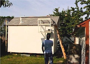 Dan is in front of his tippler loft. The Dropper is tossed and the birds above are called down. The trap is the back door of the flight box which opens to let all of the birds walk into the wire way.